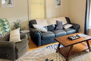 Downstairs living room with couch, comfy chair, and smart TV