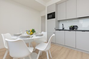 A small dining area near the window, set up with four chairs, perfect for intimate meals with a view.