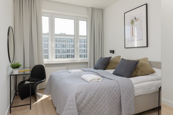 The master bedroom featuring a large double bed, modern decor, and ample natural light.