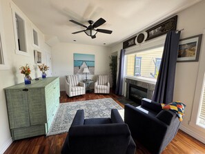 Living Room w fireplace, cabinet bed (queen), television & half bathroom
