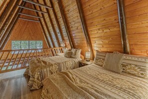 Cozy loft bedroom with double beds and warm wooden interiors