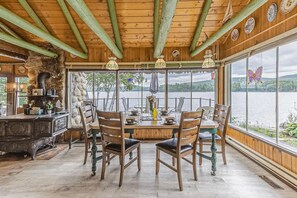 Bright dining area with large windows framing serene waterside scenery