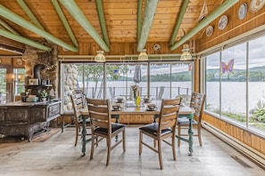 Bright dining area with large windows framing serene waterside scenery