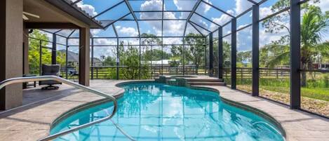 Beautiful kidney bean shaped pool with a raised spa and handrail entry to pool