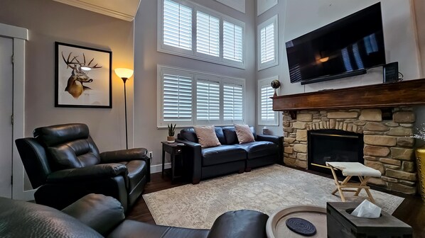 Experience the cozy living room, outfitted with plush seating, an expansive smart TV, and plenty of natural light.