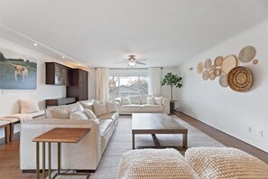 The sun-drenched main living room (1 of 3) with access to the outdoor patio.
