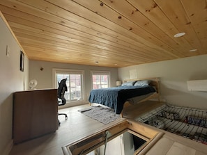 workstation, windows overlooking backyard, queen bed, and giant hammock