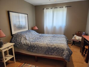 Master bedroom with queen bed, pillows and sheets.