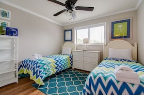 Guest bedroom with two twin beds and ample storage space