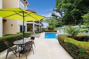 Tended gardens and ample seating for long days by the pool.