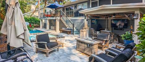 Comfortable pool deck/patio with seating under roof 