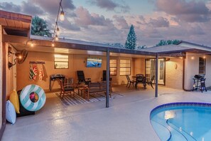 Covered Porch equipped with a TV, pizza oven, pool floats, games like tiki toss & tic-tac-toss, along with ample seating!