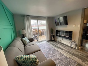 The living room offers a perfect blend of comfort, entertainment, and access to the private balcony