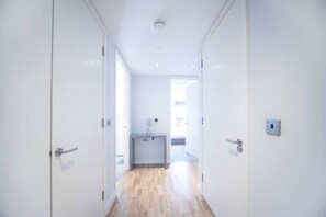 This hallway provides convenient access to a storage area and a bathroom with a bathtub.