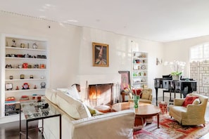 Seating in living room with fireplace and piano
