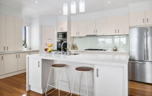 The kitchen features quality appliances, a Nespresso coffee pod machine, Caesarstone island bench, and plenty of storage
