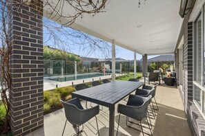 The full-width patio with an outdoor lounge and dining area provides plenty of space to relax or enjoy a meal