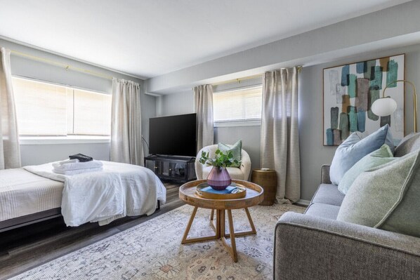 Cozy couch, coffee table, and TV positioned conveniently near the bed