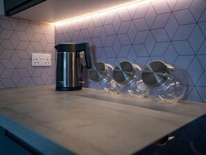 A culinary oasis where style meets functionality. Soft lights create a warm and inviting ambiance, while glass containers add a touch of elegance and practicality. 