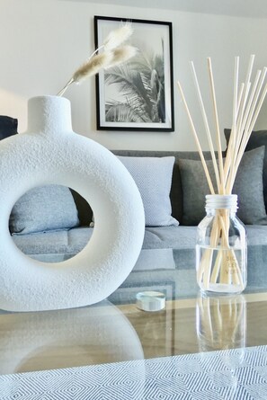 The living room is adorned with a stylish glass center table, chic designed. 
