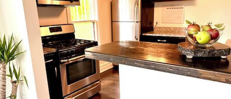 Full stocked cooks kitchen has granite countertops & stainless steel appliances
