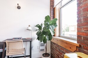 Step into The Chelsea Loft's living area, where London's Kings Road meets Stratford’s charm. High ceilings and immense windows create an airy, light-filled space, perfect for relaxation after exploring nearby Stratford Festival theatres and Avon River.