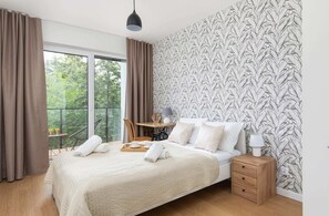 Stylish bedroom with a double bed, desk/dressing table with a chair and access to balcony.