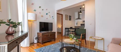 An open-plan living room, stylishly furnished, with cable TV and balcony access #lisbon #vacations #decor #airbnb #lovely