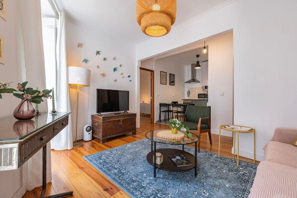 An open-plan living room, stylishly furnished, with cable TV and balcony access #lisbon #vacations #decor #airbnb #lovely