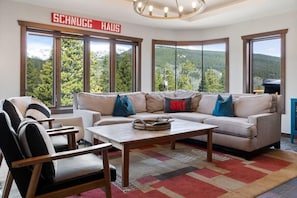 The inviting living room provides plenty of space for your entire group to relax and large windows from all around showcasing the stunning views.