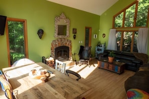 Open concept living and dining area with woodburning fireplace.