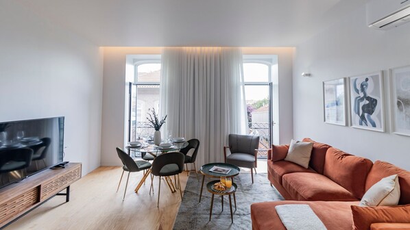 Spacious living area with a large, comfortable sofa, dining table, TV, and abundant natural light flowing in from the balcony.
#comfort