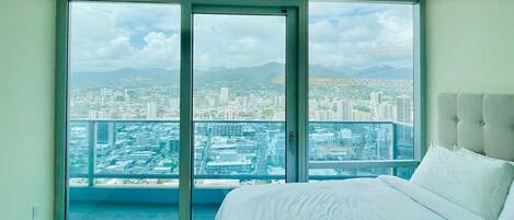 A comfy bed awaits you with a city skyline view