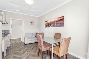 Relax and unwind in this open-plan living space, featuring a comfortable seating area and a dining table perfect for enjoying meals.