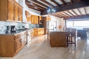 Stunning ocean vista frames the chef's kitchen in this coastal masterpiece.