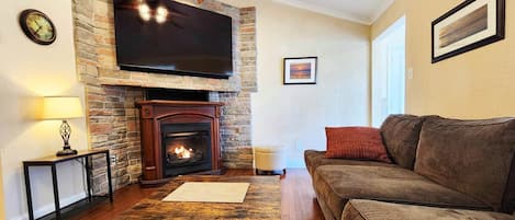 Open floor plan living room, with indoor fireplace and piano