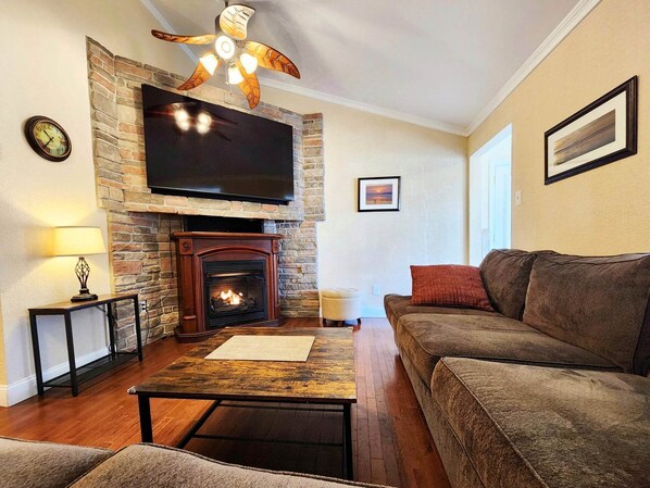 Open floor plan living room, with indoor fireplace and piano