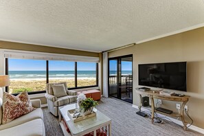 Stylishly Decorated Living and Dining Area with Breathtaking Oceanfront Views and Balcony Access