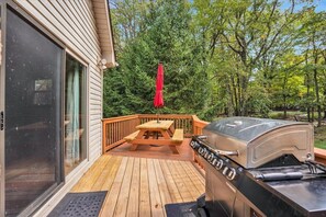 Front deck with wooden bench, umbrella and grill