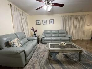 Living room with reclining chairs with open view to kitchen. 