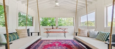 Bright and colorful porch space perfect for card games, eating at the picnic table, or relaxing with your morning coffee.