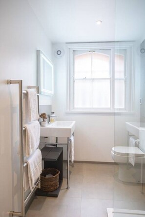 Bathroom with luxury and modern fittings and fixtures, heated towel rail, LED illuminated mirror and underfloor heating. The shower is extra large and bathroom benefits from natural light.