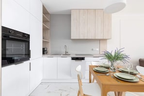 Fully equipped kitchenette with convenient cabinets, modern appliances and dining area.