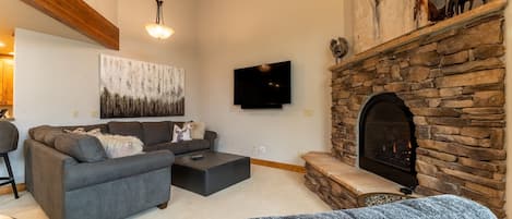 Living area featuring cozy furnishings, a gas fireplace and a mounted Smart TV.