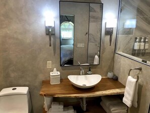 Live-edge Guanacaste counters and a blue pine barn door give this bathroom a hobbit's touch. 