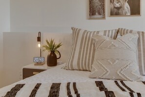 Relax in our queen bedroom, equipped with a plush 12-inch memory foam mattress, premium bedding, and a 43-inch Smart Roku TV.