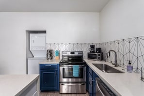 Fully equipped kitchen with sleek cabinetry, a modern backsplash, and all the essentials for cooking during your stay.