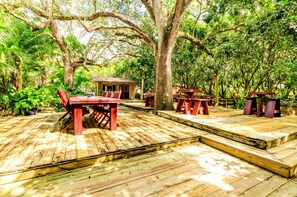 Rustic haven with weathered wood, quaint porch, lantern, and nature' embrace.
