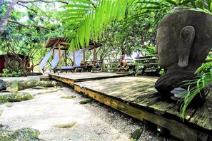 Pergola in vibrant Japanese garden with cascading vines and shaded stone paths.