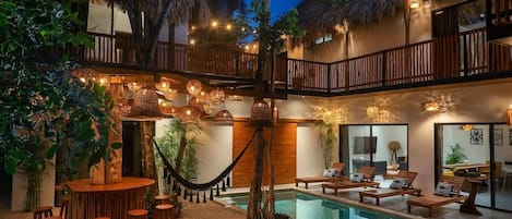 Incredible patio with a pool and an outdoor bar. Unique design that combines elegance with natural materials like bamboo and wood.